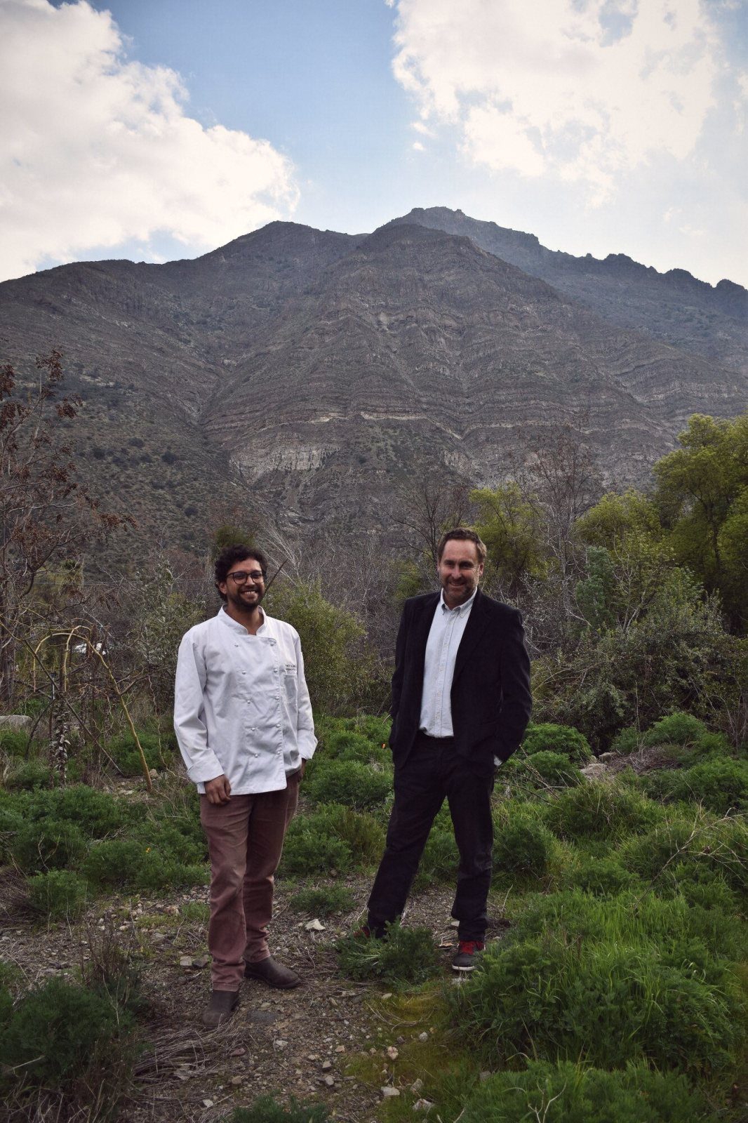Kurt Thiele y Germán Ilabaca en un campo con cerros de fondo
